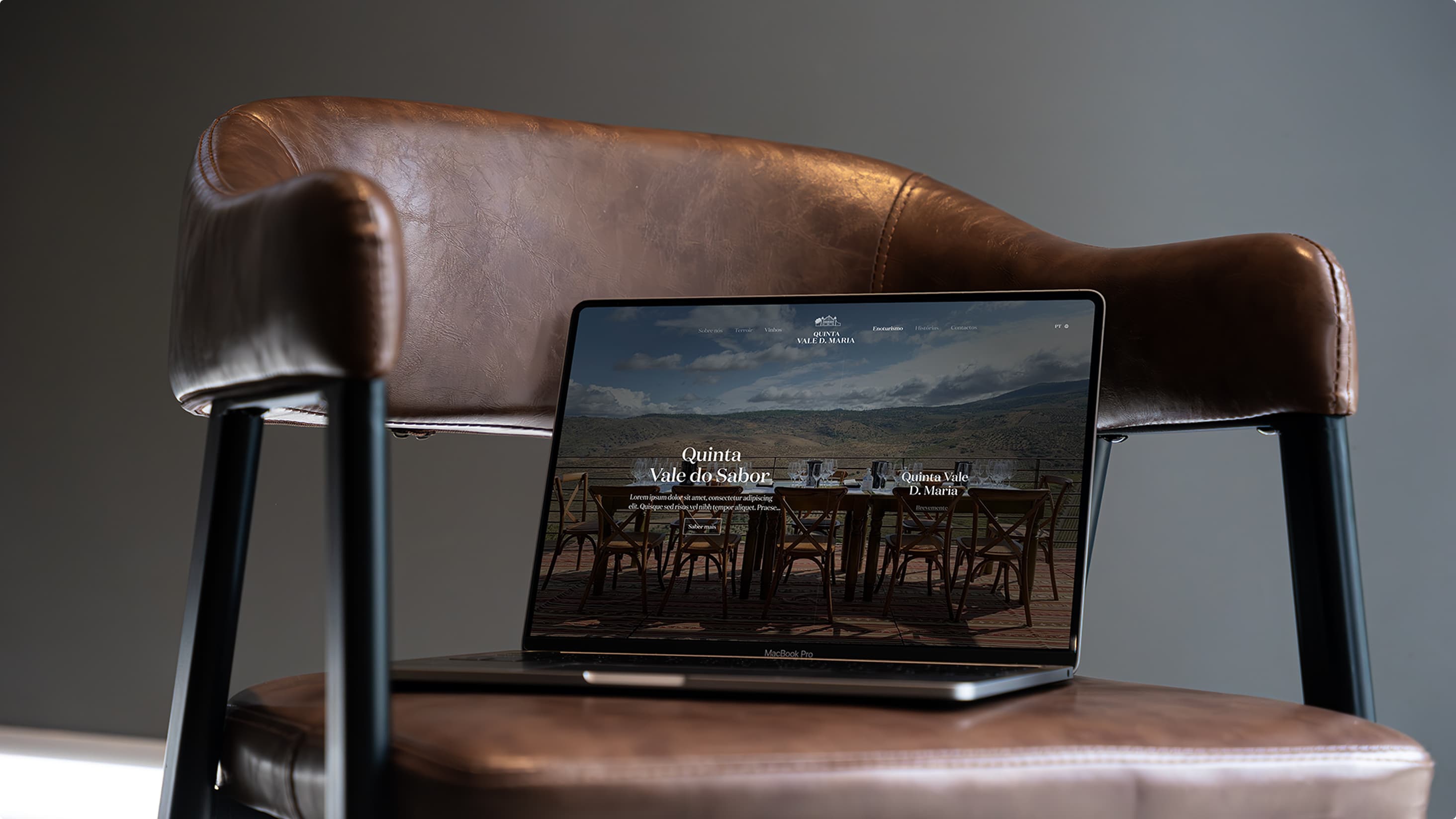 The Quinta Vale D. Maria website on a laptop resting on a leather armchair